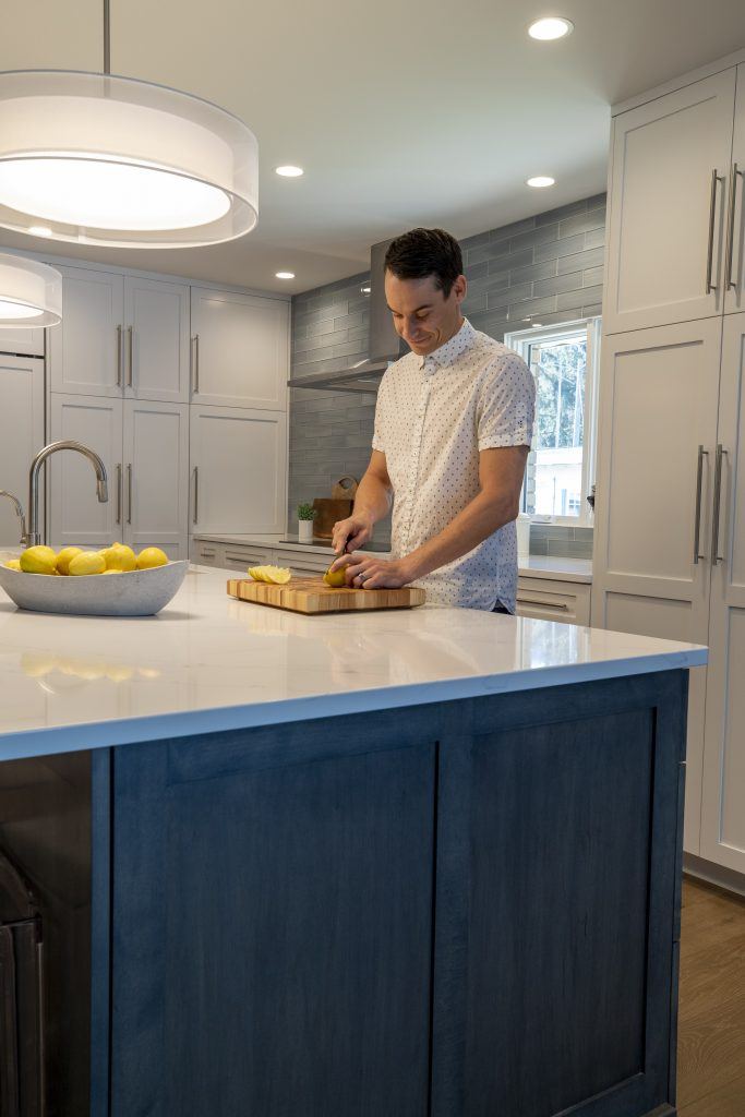 Modern Kitchen with man cutting lemons